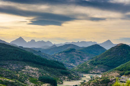 Beautiful landscape in Spain with dramatic view of Cantabrian Mountains. Power line running along the dried river bed at sunriseの写真素材