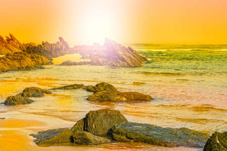 Portuguese Atlantic Ocean beach in the morning mist at sunrise. Breathtaking landscape and nature of the Portugal, popular travel destination in western Europe. の写真素材