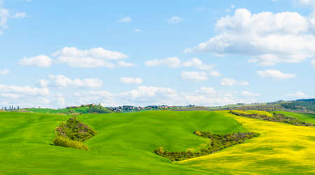 Italian landscape with meadows early in the spring. Agriculture in Italy, fields, pastures and farmhouses on the hill.の写真素材