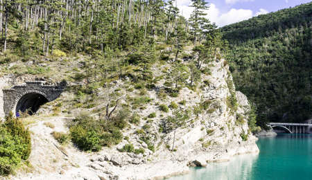 Wooded shore of the lake in French Alps. Lake Castillon is a reservoir in Alpes-de-Haute-Provence in France.の写真素材