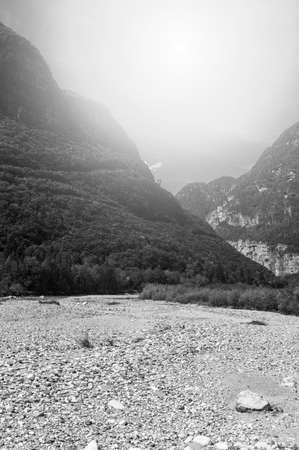 Morning mist in Italian Alps. View of the mountain dry riverbed in Italy at sunrise. Black and white picture の写真素材