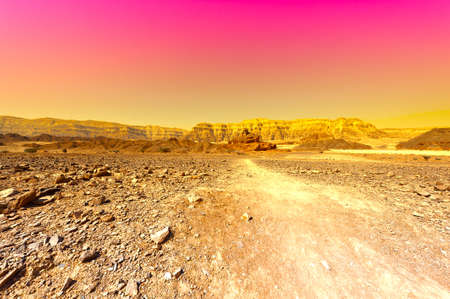 Raging colors of the rocky hills of the Negev Desert in Israel. Breathtaking landscape and nature of the Middle East at sunsetの写真素材