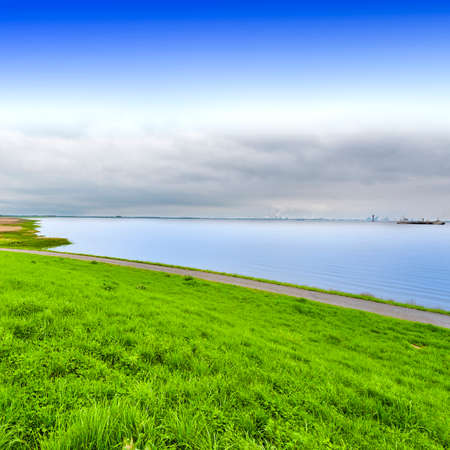 Dunes and sea at the North Sea shore in Holland. Dutch landscape with dike protects against floodingの写真素材