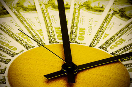 Hundred-dollar banknotes  lying on the hour dial and symbolizing time is money. Retro styleの写真素材
