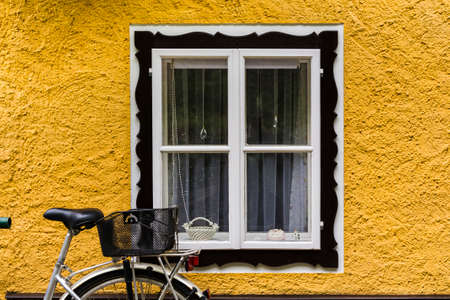 Bike at home in the Austrian city of Hallstatt on a rainy day. Typical window of a house in a small...