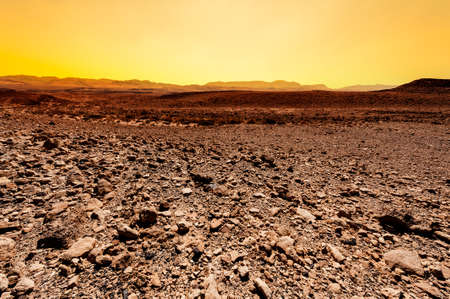 Rocky hills of the Negev Desert in Israel at sunset. Breathtaking landscape of the rock formations in the Southern Israel. Dusty mountains interrupted by wadis  and deep craters.の写真素材