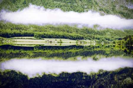  Rain and clouds on the Hallstattersee in Austria. Morning mist over the Austrian landscape with lake, forests, fields, pastures, meadows and village. Vintage styleの写真素材