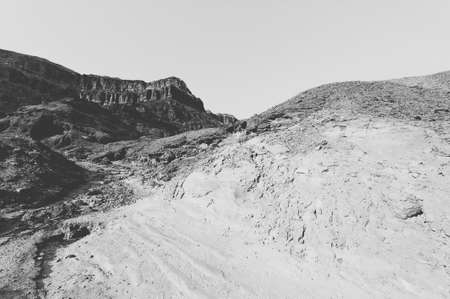Loneliness and emptiness of the rocky hills of the Negev Desert in Israel. Breathtaking landscape and nature of the Middle East. Black and white photoの写真素材