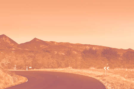 Winding paved road in the delightful landscape of the French Alps at dawn in a contemporary style.の写真素材