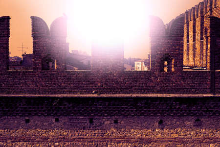 The Castel Vecchio Bridge or Scaliger Bridge is a fortified bridge in Verona, northern Italy, over the Adige River at sunsetの写真素材