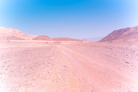 Breathtaking landscape of the rock formations in the Israel desert in faded color effect. Lifeless and desolate scene as a concept of loneliness, hopelessness and depression.の写真素材