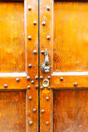 Metal ornamentation of Italian wooden door in Tuscanyの写真素材