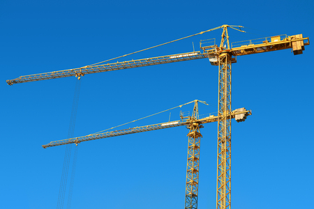 Tower cranes on a blue sky background の写真素材