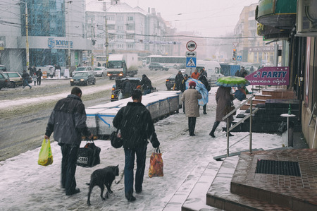 KALININGRAD, RUSSIA - JAN 12, 2012: Kaliningrad street during a snow-storm, some pedestrians hurry to take cover from a windのeditorial素材