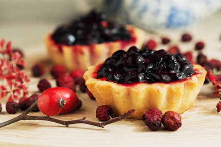 Sweet cupcakes with fresh organic strawberries on wooden table