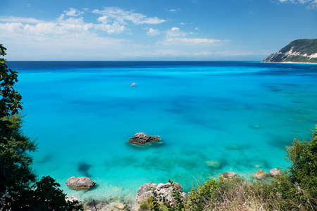 Beautiful tropical lagoon seascape with white boat in blue water. Greece, Lefkada island.の写真素材