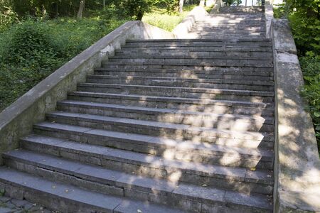 Stone staircase with glare from the sun amid the greeneryの写真素材