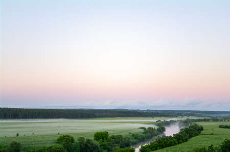 Landscape with river and trees, fields and clouds.の写真素材