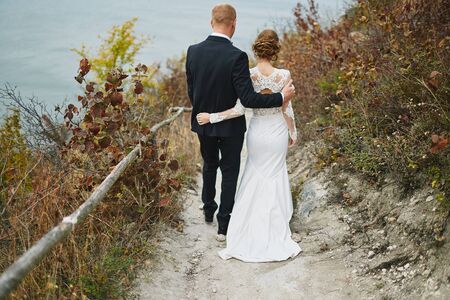 photoshoot lovers in a wedding dress in the mountains near the sの写真素材