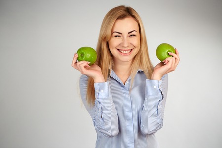 Healthy girl in diferent emotions, with green appleの写真素材