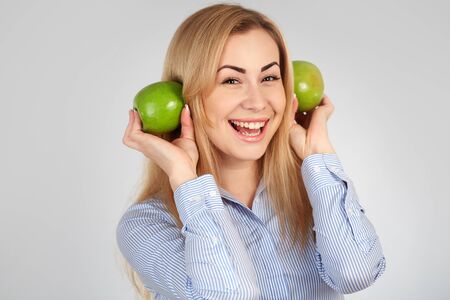 Healthy girl in diferent emotions, with green appleの写真素材