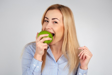 Healthy girl in diferent emotions, with green appleの写真素材