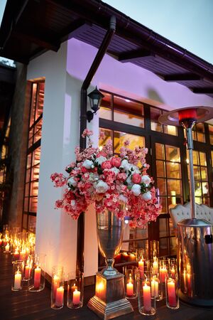 Beautiful candles with flowers near house, eveningの写真素材