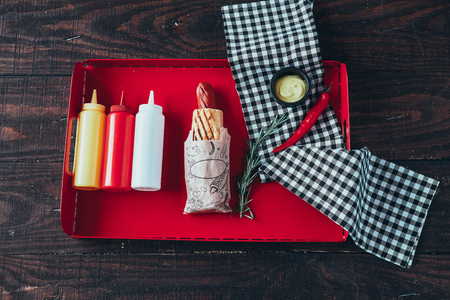 Hot dog with mustard, ketchup and mayonnaise on wooden background. Top viewの写真素材