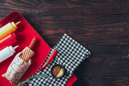 Hot dog with mustard, ketchup and mayonnaise on wooden background. Top viewの写真素材