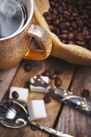A cup of coffee, coffee beans on a wooden backgroundの写真素材