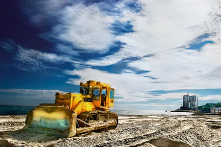 Tractor on a sandy beach near the seaの写真素材