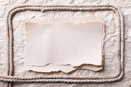 ripped piece of paper and rope on old crushed paper background. vintage retro card の写真素材