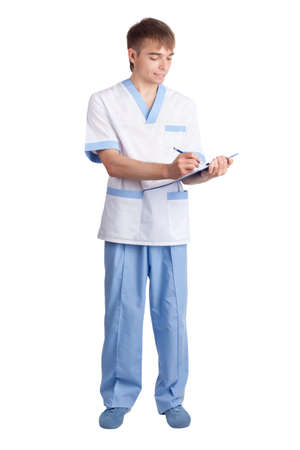  young smiling medical doctor fills the form in clipboard isolated on white backgroundの写真素材