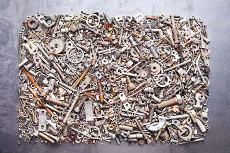 Rectangle from assorted nuts and bolts on metal texture background
