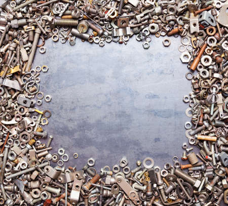 assorted nuts and bolts square frame on metal texture backgroundの写真素材