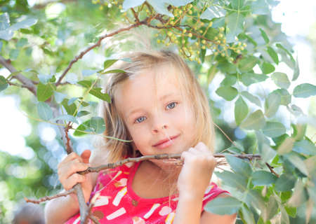 Portrait of the beautiful blonde little girl on natureの写真素材