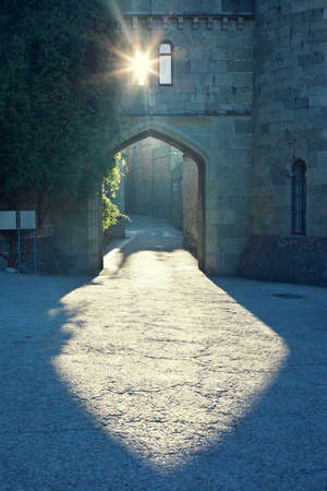 Light falling through an arch and lock window. Mysterious urban scene. Ancient street. の写真素材