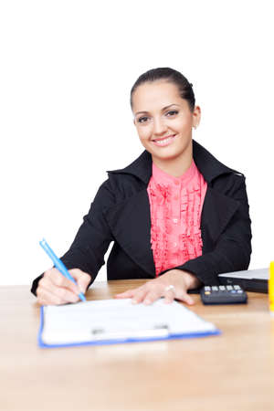 beautiful young business woman writing on clipboard on her desk isolated on white backgroundの写真素材