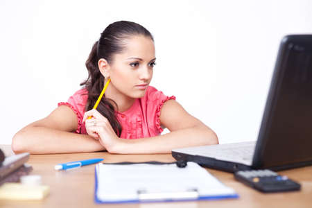 beautiful young woman sitting at office desk and working on laptop の写真素材