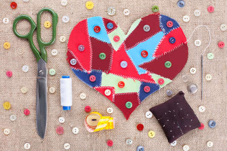 Sewing accessories and fabric scraps heart on fabric texture background . Valentineの写真素材