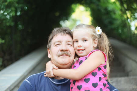 Portrait of grandfather with granddaughter outdoor の写真素材