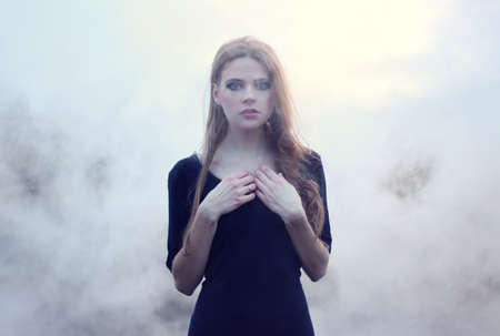 sensual beautiful girl in white smoke on natureの写真素材