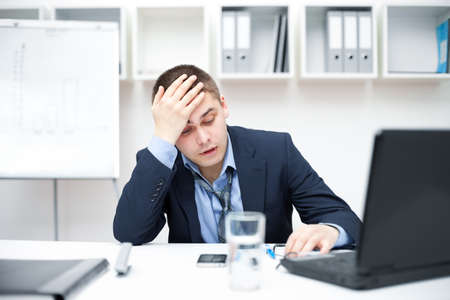 Thoughtful or stressful businessman at workの写真素材