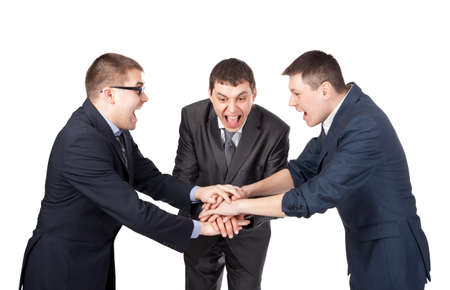 Three laughing partners putting their hands on the top isolated on white backgroundの写真素材