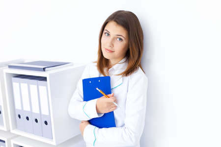 Portrait of young female doctor holding clipboard in hospitalの写真素材
