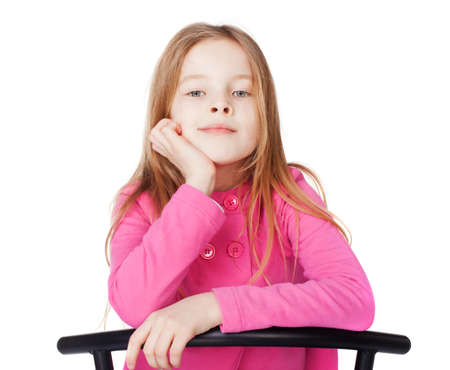 Portrait of little girl sitting her chin on hand isolated on white backgroundの写真素材