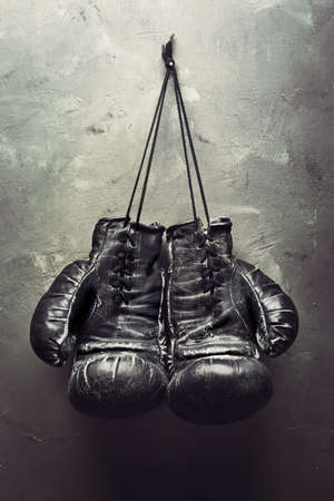 old boxing gloves hang on nail on textured wall - Retirement conceptの写真素材