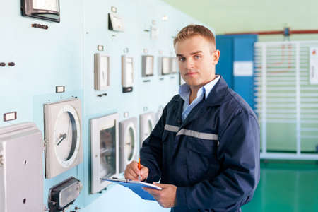 Portrait of young engineer taking notes at control roomの写真素材