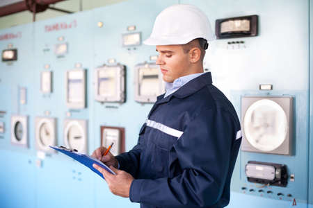 Portrait of young engineer taking notes at control roomの写真素材