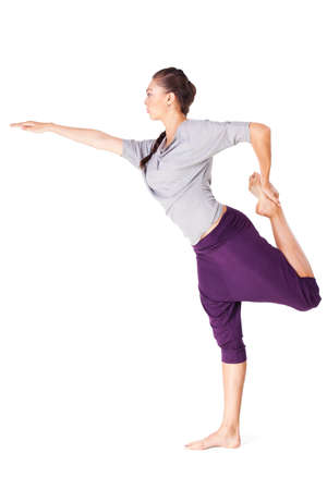 Young woman doing yoga exercise Natarajasana (Lord of the Dance Pose). Isolated on white background の写真素材